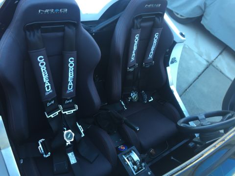 2015 Subaru Impreza - The interior of a car shows two Corbeau racing seats with NRG harnesses and a racing steering wheel.