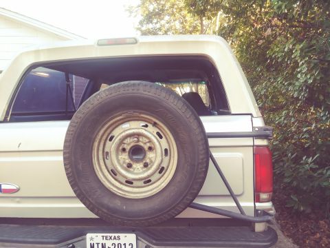 1996 Ford Bronco - Rear view of a 1996 Ford Bronco, showing the spare tire and tailgate.