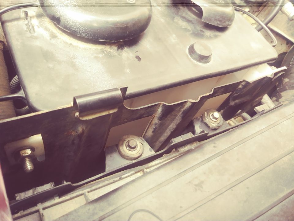 Close-up of a vehicle's engine air intake housing and mounting hardware
