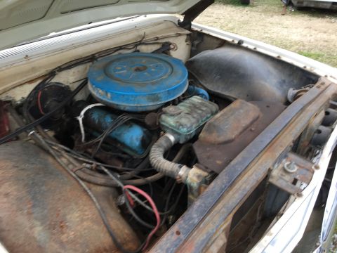 1960 Ford Starliner - The engine bay of a vintage vehicle, showing the air cleaner, hoses, and engine block.