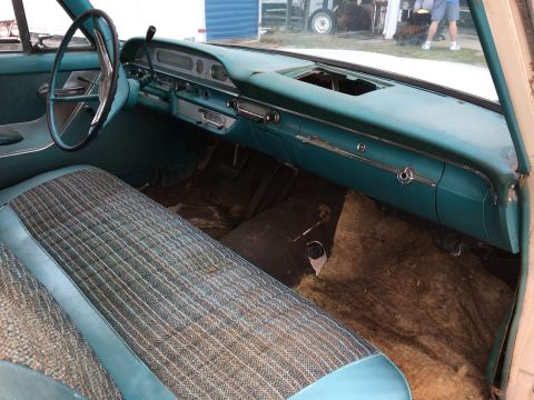 1960 Ford Starliner - Interior view of a 1960 Ford Starliner, its distinctive teal dashboard and patterned fabric seats.