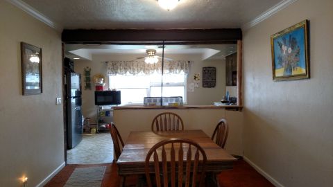 1980 Yugo Vega - Dining area and kitchen interior, showing a table, chairs, refrigerator, and microwave.