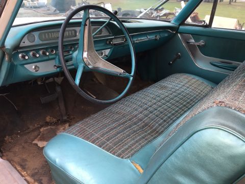 1960 Ford Starliner - The interior of a 1960 Ford Starliner shows turquoise vinyl and plaid upholstery, a large steering wheel, and a dashboard with a speedomete…