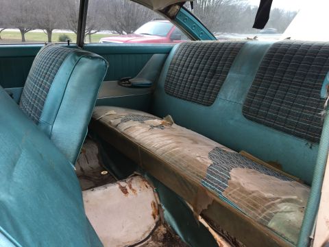 1960 Ford Starliner - Interior view of a 1960 Ford Starliner, highlighting the worn rear seat and teal trim.