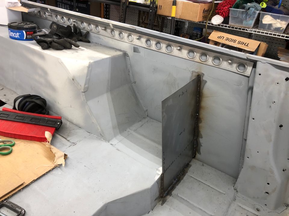 Interior of a vehicle undergoing repair, showing metalwork and tools