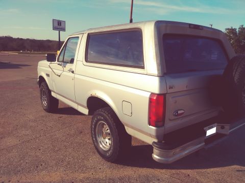 1996 Ford Bronco - Rear view of a silver Ford Bronco, showing its spare tire and taillight assembly.