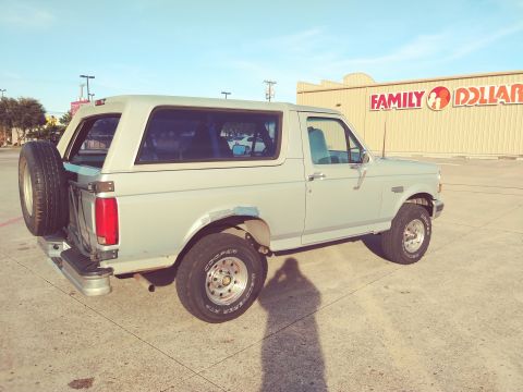 1996 Ford Bronco - A light gray 1992 Ford Bronco is parked in front of a Family Dollar store.