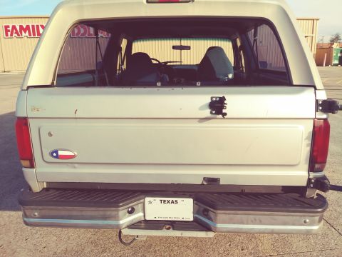 1996 Ford Bronco - This Ford Bronco is seen from the rear, showing its Texas license plate and a Texas flag emblem.