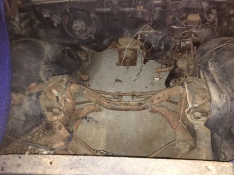 1961 Ford Starliner - The engine bay of a vehicle shows significant rust and wear on its components.