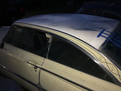 1961 Ford Starliner - The roof of a vintage car is being worked on, with blue tape holding some material in place.