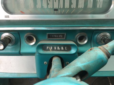 1960 Ford Starliner - The interior of a 1960 Ford Starliner features a turquoise dashboard with a speedometer and a PRND2L gear selector.