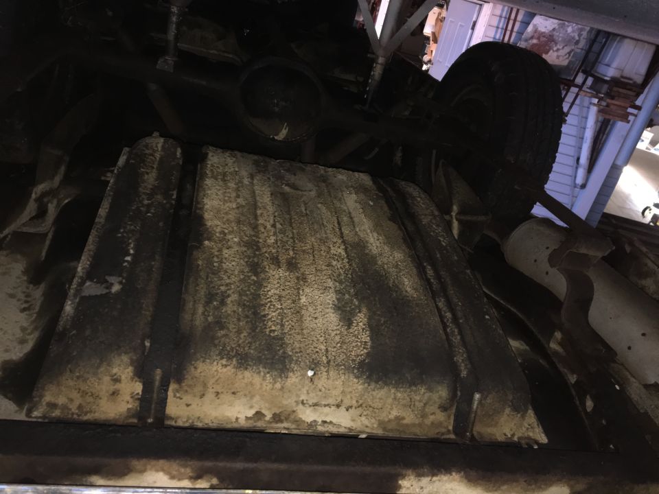 Underside view of a vehicle showing the fuel tank and exhaust system