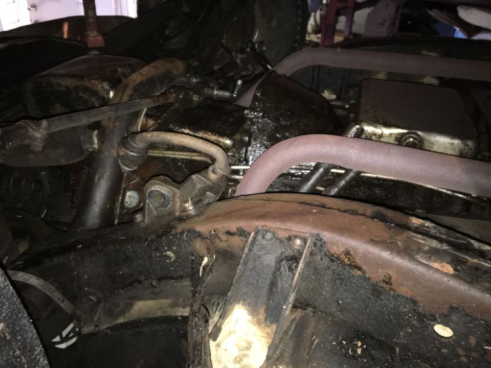 Engine bay with rusty frame and oily components