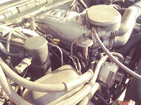 1996 Ford Bronco - Close-up view of the engine compartment, showing various mechanical components and hoses.