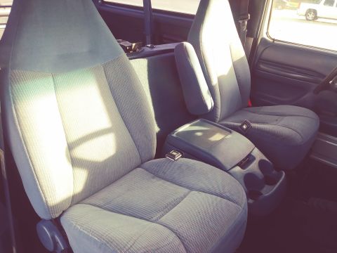 1996 Ford Bronco - Front interior of a 1996 Ford Bronco, bucket seats and a center console.