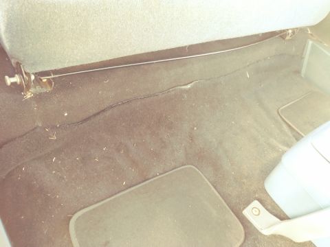 1996 Ford Bronco - The interior floor of a vehicle shows dark carpeting and a floor mat, with a watermark at the bottom.