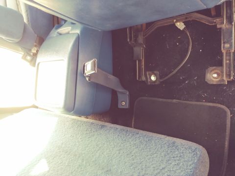 1996 Ford Bronco - Interior view of a vehicle showing a seatbelt assembly and a floor mat, with a Supermotors.net watermark visible.