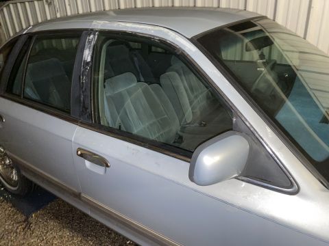 1994 Ford Crown Victoria - A light blue sedan is viewed from the side, revealing its interior and exterior details.