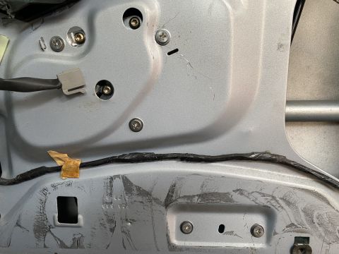 1994 Ford Crown Victoria - Close-up view of the wiring and mounting points inside a vehicle's door panel.