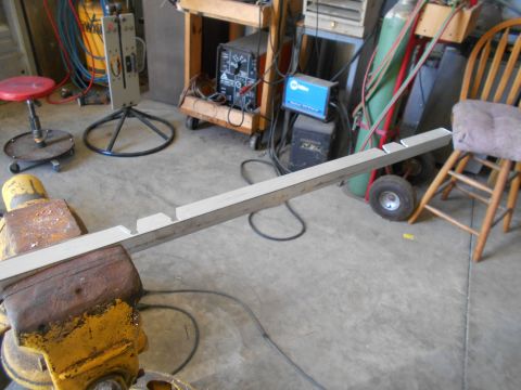 1992 Ford Bronco - A metal bar is secured in a vise, with various tools and equipment visible in the workshop setting.