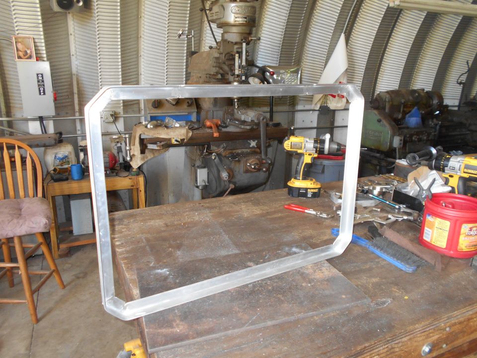Aluminum frame with octagonal shape on a workbench with tools and machinery in the background