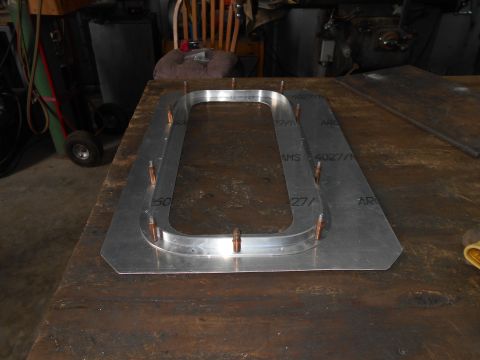 1992 Ford Bronco - A metal component with an oval opening is fastened with bolts to a workbench.
