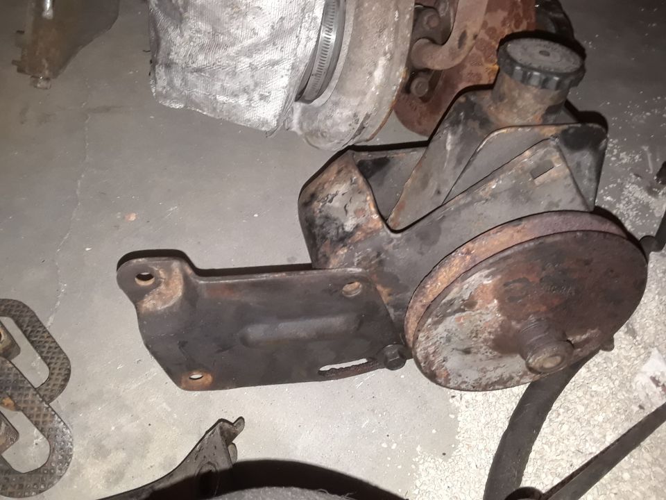 Power steering pump with pulley and reservoir cap. Some rust visible