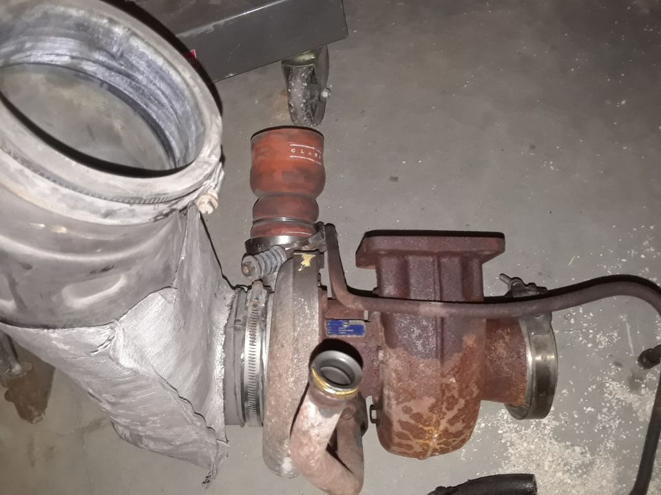 Rusty turbocharger connected to a large, torn intake pipe