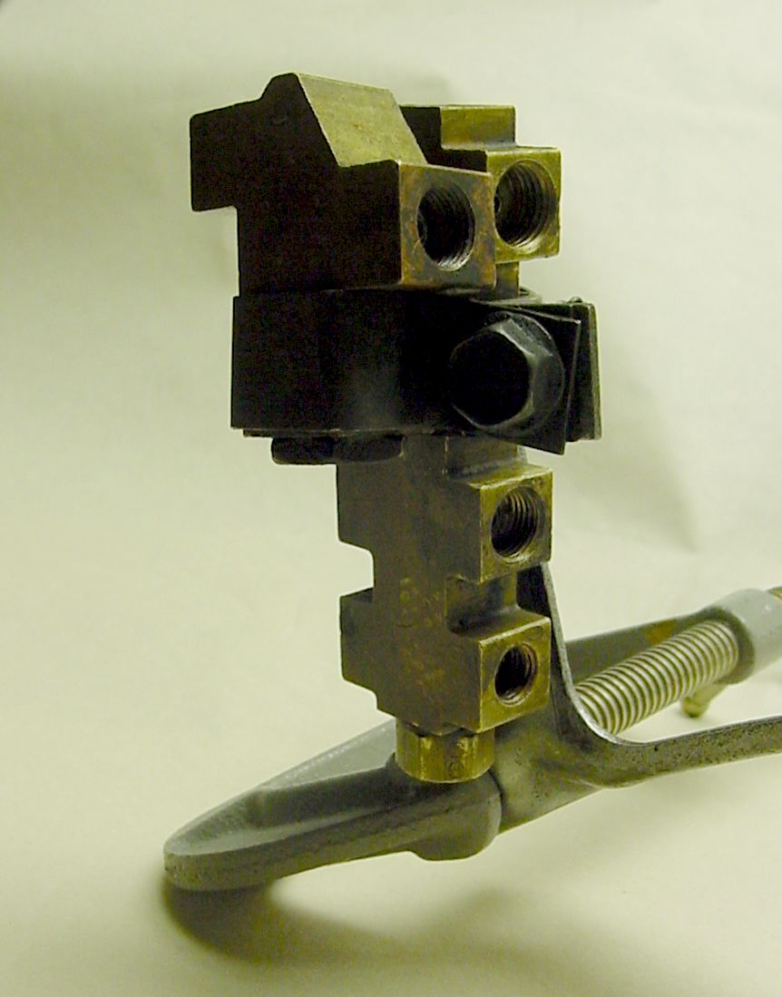 Brake proportioning valve with brass and black metal components and a spring