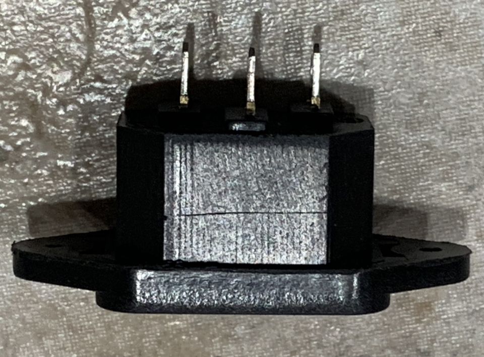 Black three-pin electrical connector with hexagonal body and mounting flanges