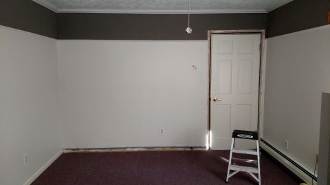 1980 Yugo Vega - This is an empty room with white walls and dark carpet.