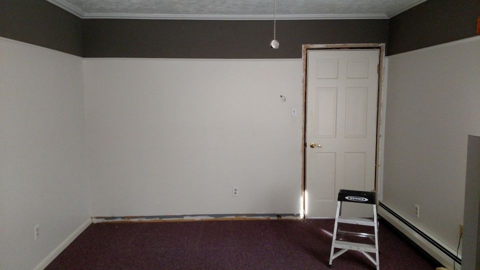 Interior of an empty room with white walls and dark carpet