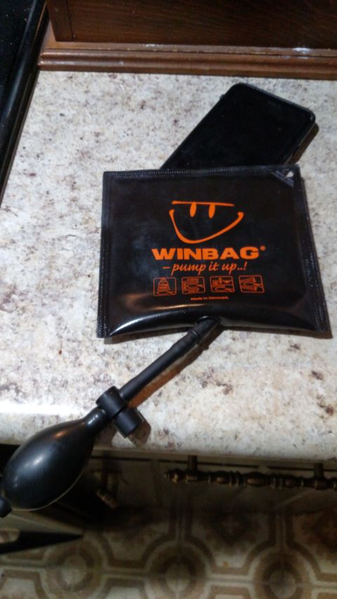 1980 Yugo Vega - A WINBAG inflatable wedge and pump are shown with a smartphone on a kitchen counter.