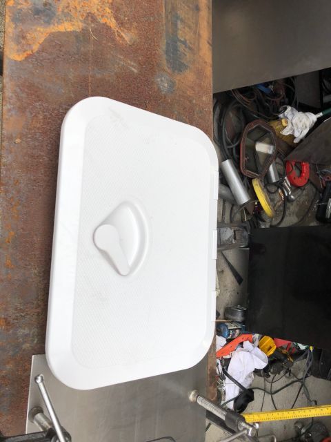 1992 Jeep Wrangler - A white access panel with a handle is shown on a rusty surface, with tools in the background.
