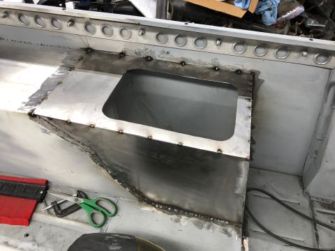 1992 Jeep Wrangler - A close-up view of metal fabrication work on the interior floor of a vehicle, likely a Jeep Wrangler, showing newly welded panels and a cut…