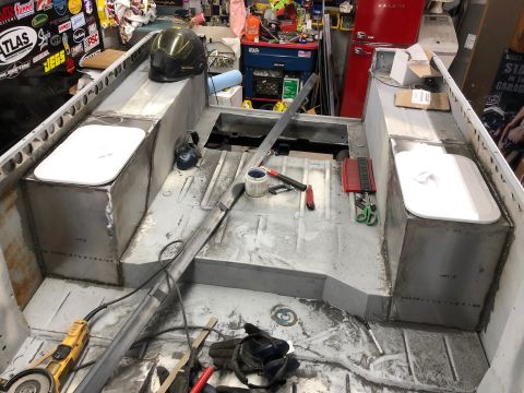1992 Jeep Wrangler - The interior of a boat under construction shows metal fabrication with welded seams and two white molded seats. Tools and supplies are scat…