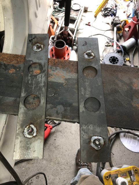 1992 Jeep Wrangler - Two metal plates with welded nuts are attached to a rusty metal frame, possibly for a vehicle modification. The plates have circular cutout…