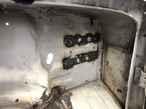 1992 Jeep Wrangler - Two welded metal brackets with multiple circular cutouts are attached to the interior wall of a vehicle. The vehicle's interior appears to…