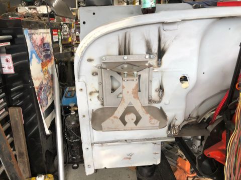 1992 Jeep Wrangler - A custom metal bracket is welded to the inner fender well of a vehicle, likely a Jeep Wrangler, in a workshop setting. The bracket is silve…