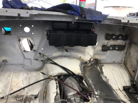 1992 Jeep Wrangler - The interior firewall of a vehicle is shown, with a black HVAC unit mounted centrally. Several control cables extend through a large openin…