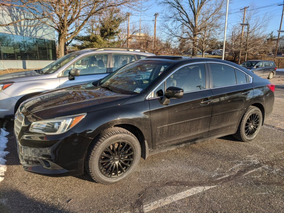 Black sedan with black alloy wheels parked at front 3/4 angle in winter lot