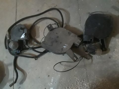 1994 Ford Bronco - A set of black automotive parts, likely from a 1994 Ford Bronco, are laid out on a concrete floor. The parts include a large black plastic…