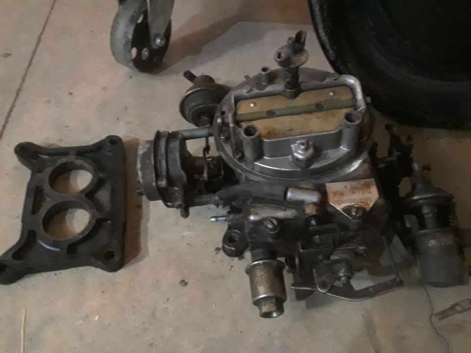 Carburetor and intake manifold adapter on concrete floor