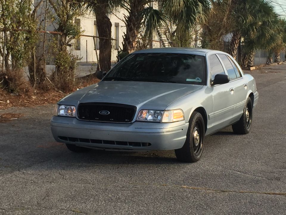 Light blue Ford Crown Victoria sedan, 3/4 front view.