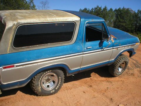 1978 Ford Bronco - This 1978 Ford Bronco features a two-tone blue and silver paint scheme and off-road tires, seen here on a dirt incline.
