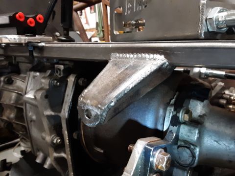 1985 Toyota Hilux - Close-up view of a custom metal bracket welded to a transmission housing. The bracket has a single mounting hole and is attached to a large…
