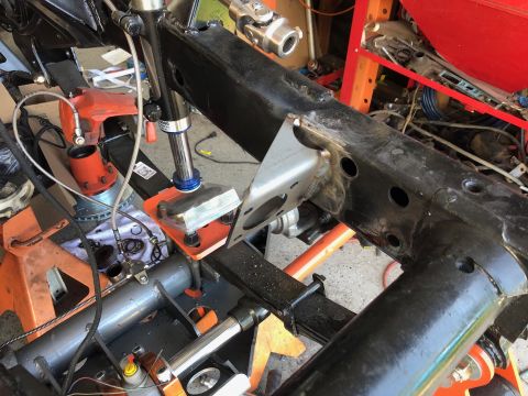 1992 Jeep Wrangler - A black Jeep Wrangler frame is shown with various suspension components and brake parts installed. The vehicle is supported by orange jack…