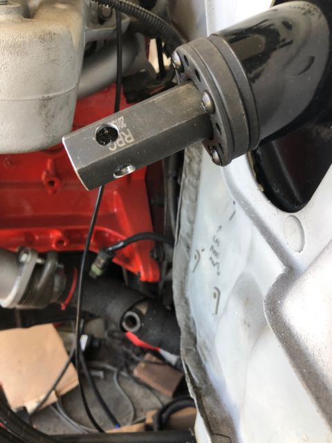 1992 Jeep Wrangler - A close-up view shows a metal adapter with "RPC 2015" etched into it, connected to a black component. The adapter is positioned near a red…