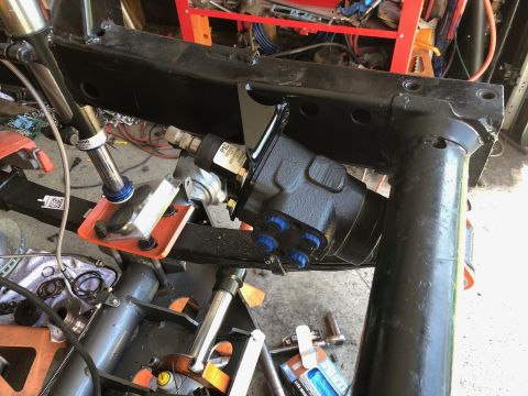 1992 Jeep Wrangler - A black power steering gearbox is mounted to the frame of a vehicle, with various suspension and steering components visible in the foregro…