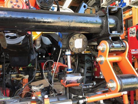 1992 Jeep Wrangler - A close-up view of the underside of a vehicle's suspension system, featuring a black axle housing, an orange suspension component, and vari…